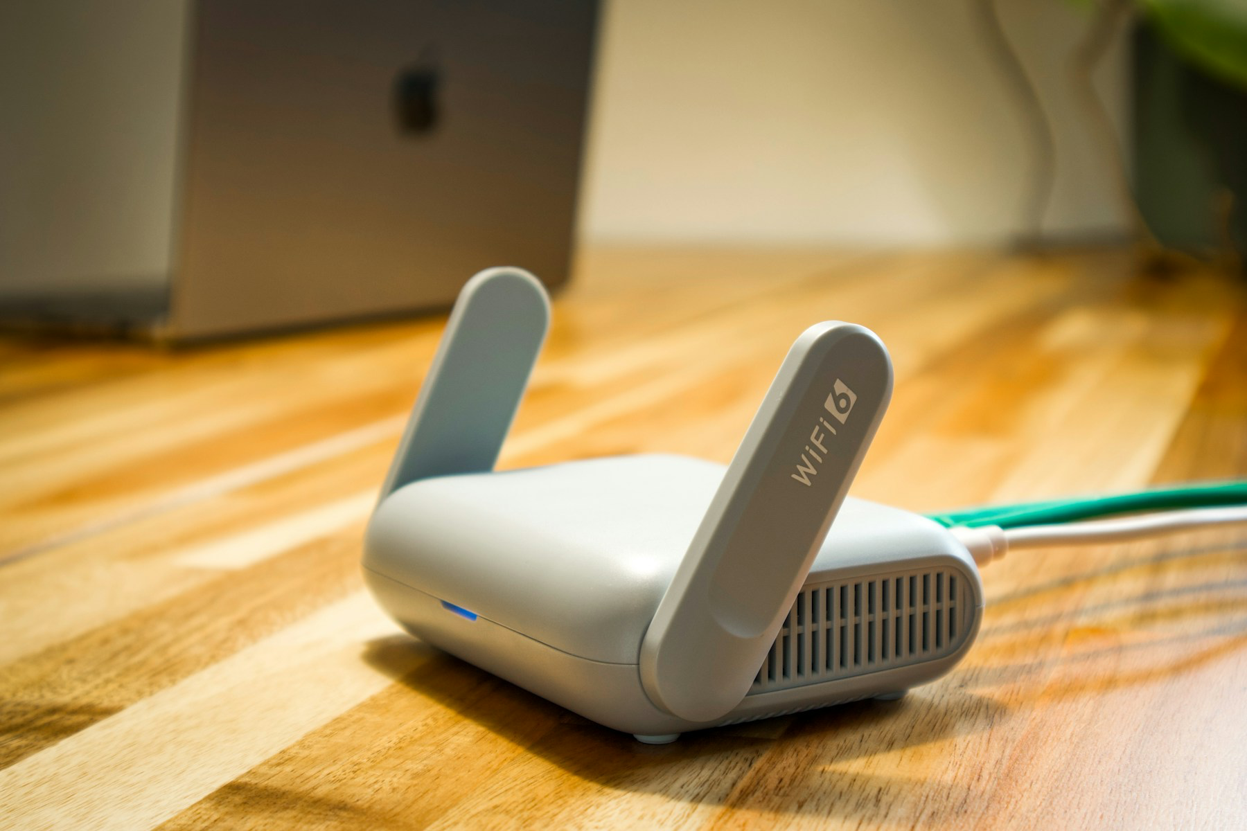 라우터와 MacBook이 놓인 테이블의 Wi-Fi 작업 환경 자료 사진