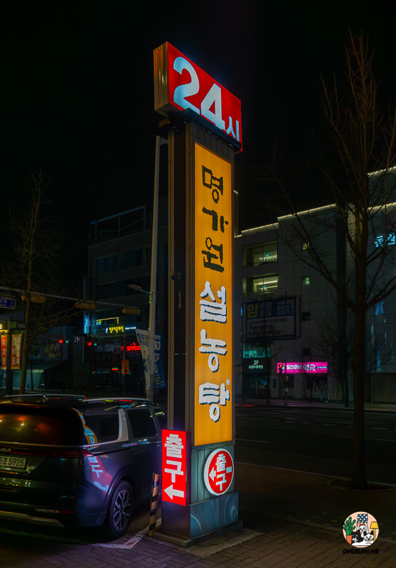 명가원 설농탕의 큰 입간판. 24시간 운영을 강조하는 붉은색 조명과 '출구' 안내 표시가 있다.