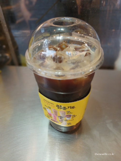 아침 공복에 마시는 아이스커피 컵 실사 사진, 위장에 부담을 줄 수 있는 공복 커피 습관을 보여줌