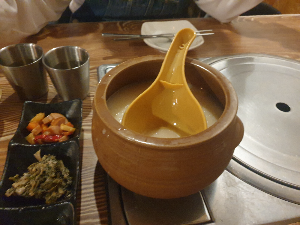 작은 플라스틱 항아리 안에 살얼음 동동주와 표주박이 들어있다.