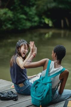 남여-친구가-놀러가서-환하게-웃으며-서로-마주보고-하이파이브를-하는-모습