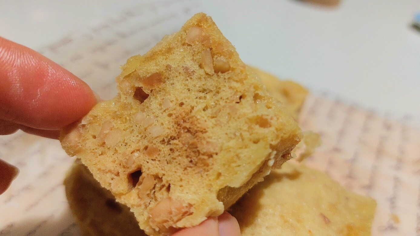 땅콩 입자가 보이는 빵을 집어 올린 사진