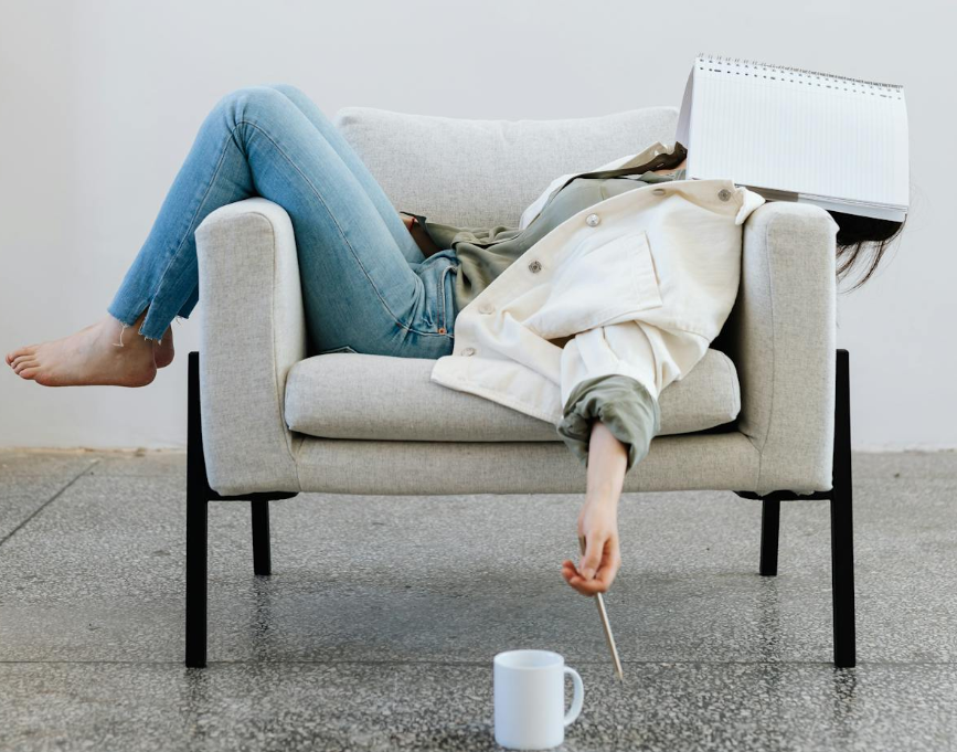 소파에 누워 지친 모습으로 휴식을 취하는 사람, 만성 피로와 스트레스로 인한 무기력 표현