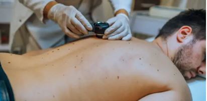 누워있는 남성 등에 점이 많은데 전문의가 보고있는 사진