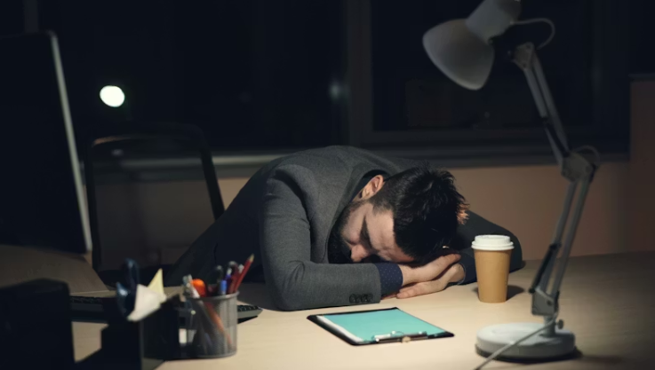 만성 피로로 인해 책상에서 잠든 직장인의 모습