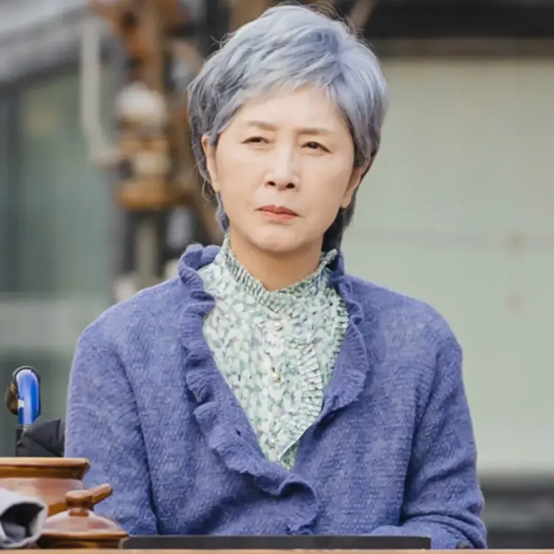 실외 테라스 나무 의자에 백발 머리와 남보라색 옷을 입고 있는 드라마 이 연애는 불가항력의 은월 캐릭터