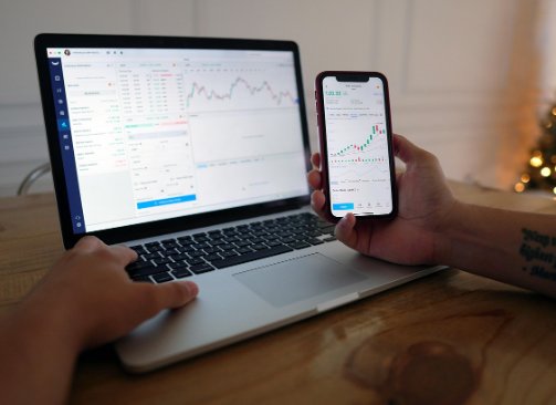 노트북과 스마트폰으로 주식 차트를 확인하는 모습