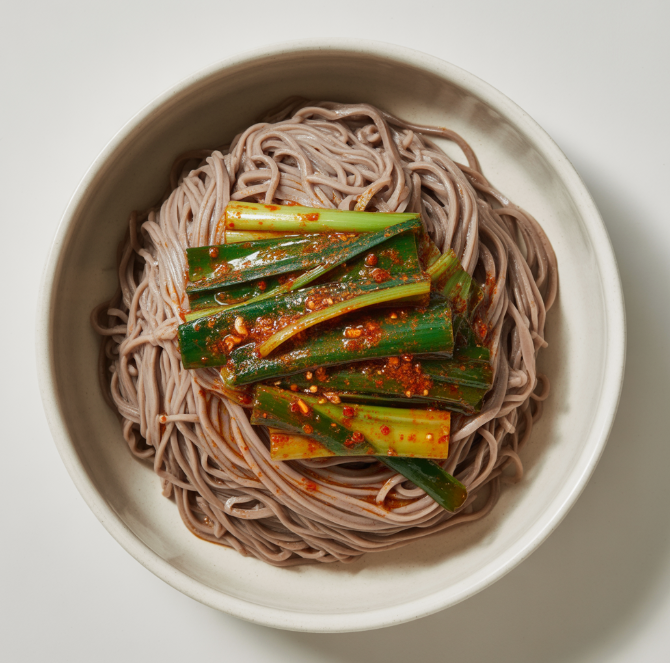 막국수 위에 파김치 고명을 얹은 색감 가득한 탑뷰 사진