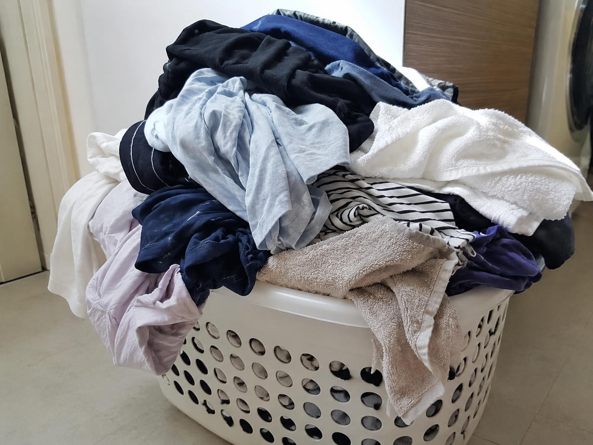 빨래 바구니에 가득 쌓인 빨래 사진