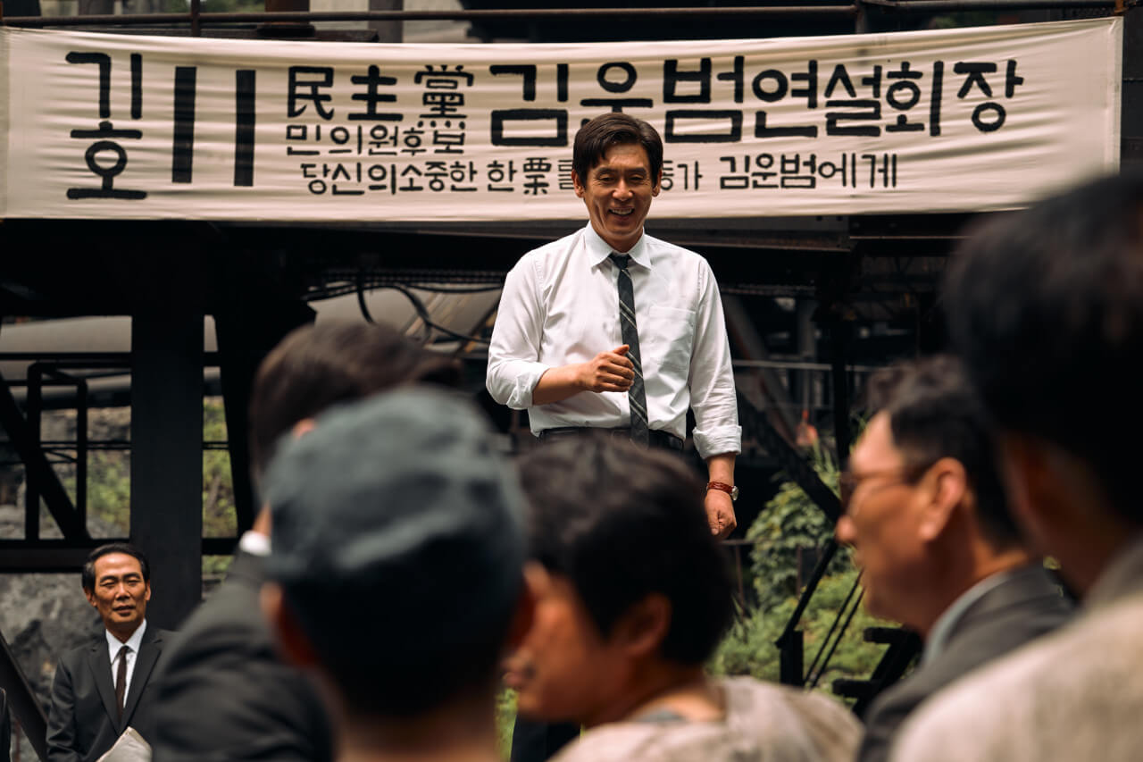 김운범이 연설 현장에서 웃으며 단상에 서 있는 모습
