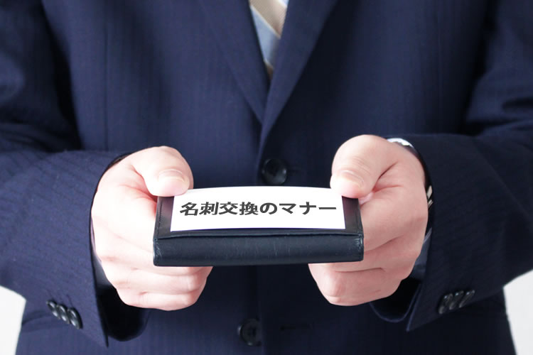 명함을 명함지갑 위에 올려서 건네고 있다