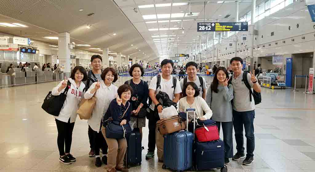 단체여행을 떠나는 사람들이 공항에서 기념 촬영