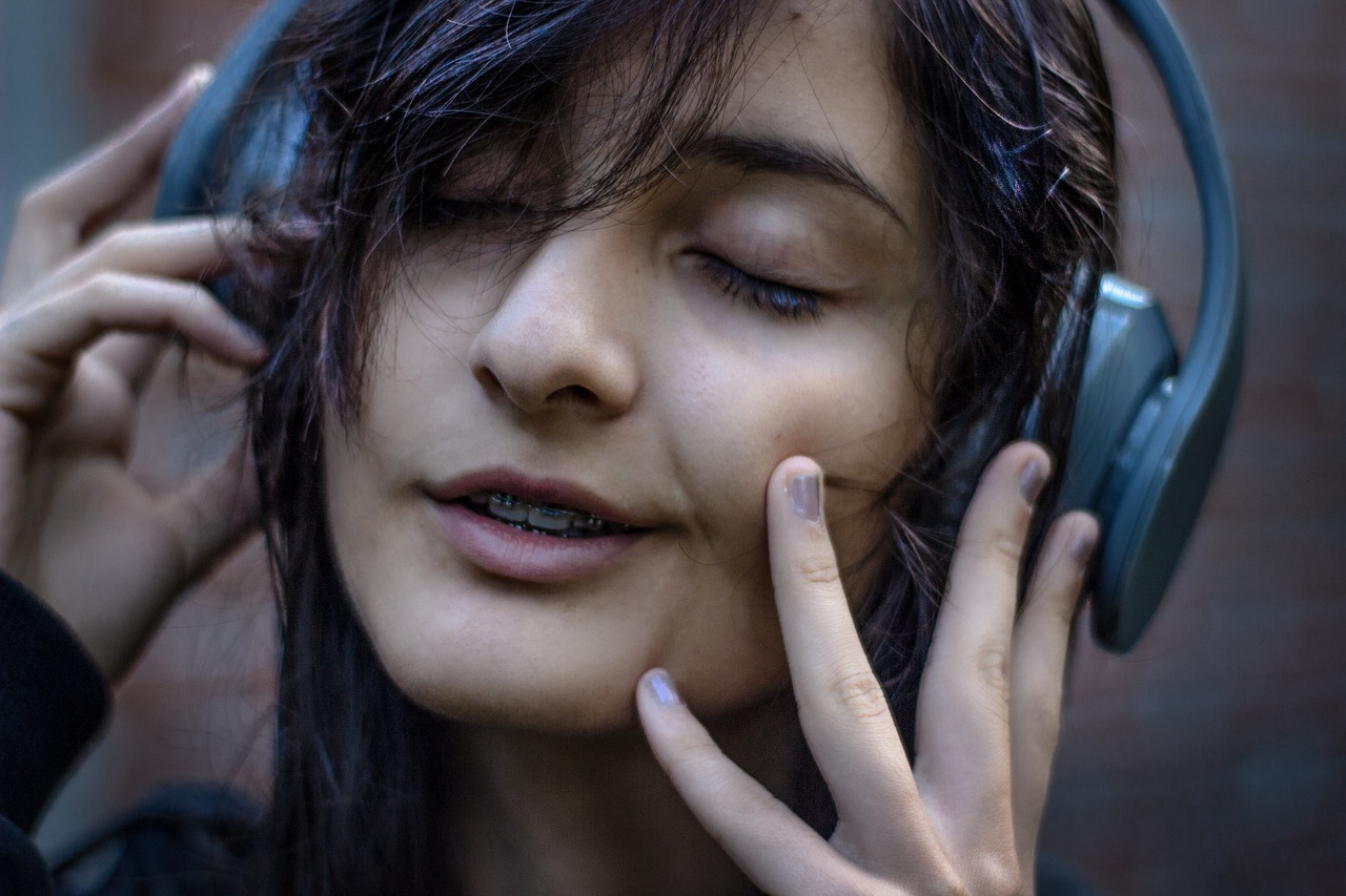 헤드폰을 끼고 음악을 듣는 여성