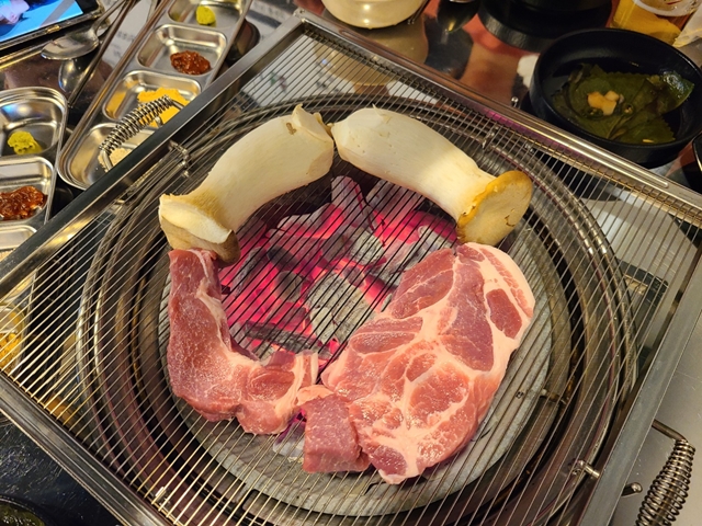 불판위에 올라가있는 목살과 새송이버섯