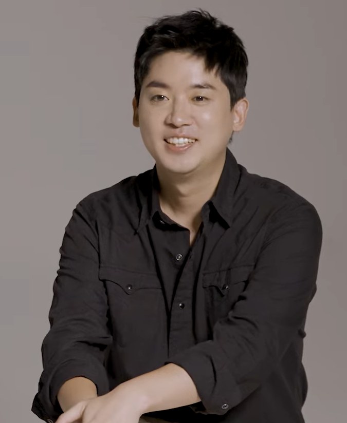 어두운 셔츠를 입고 미소 짓는 배우 조현철