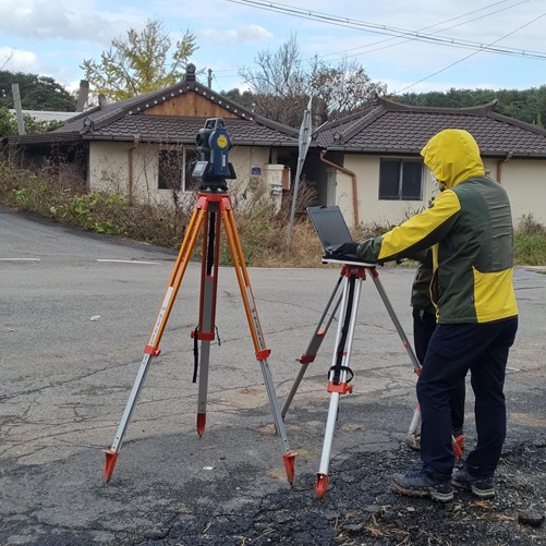 지적 측량하는 장면
