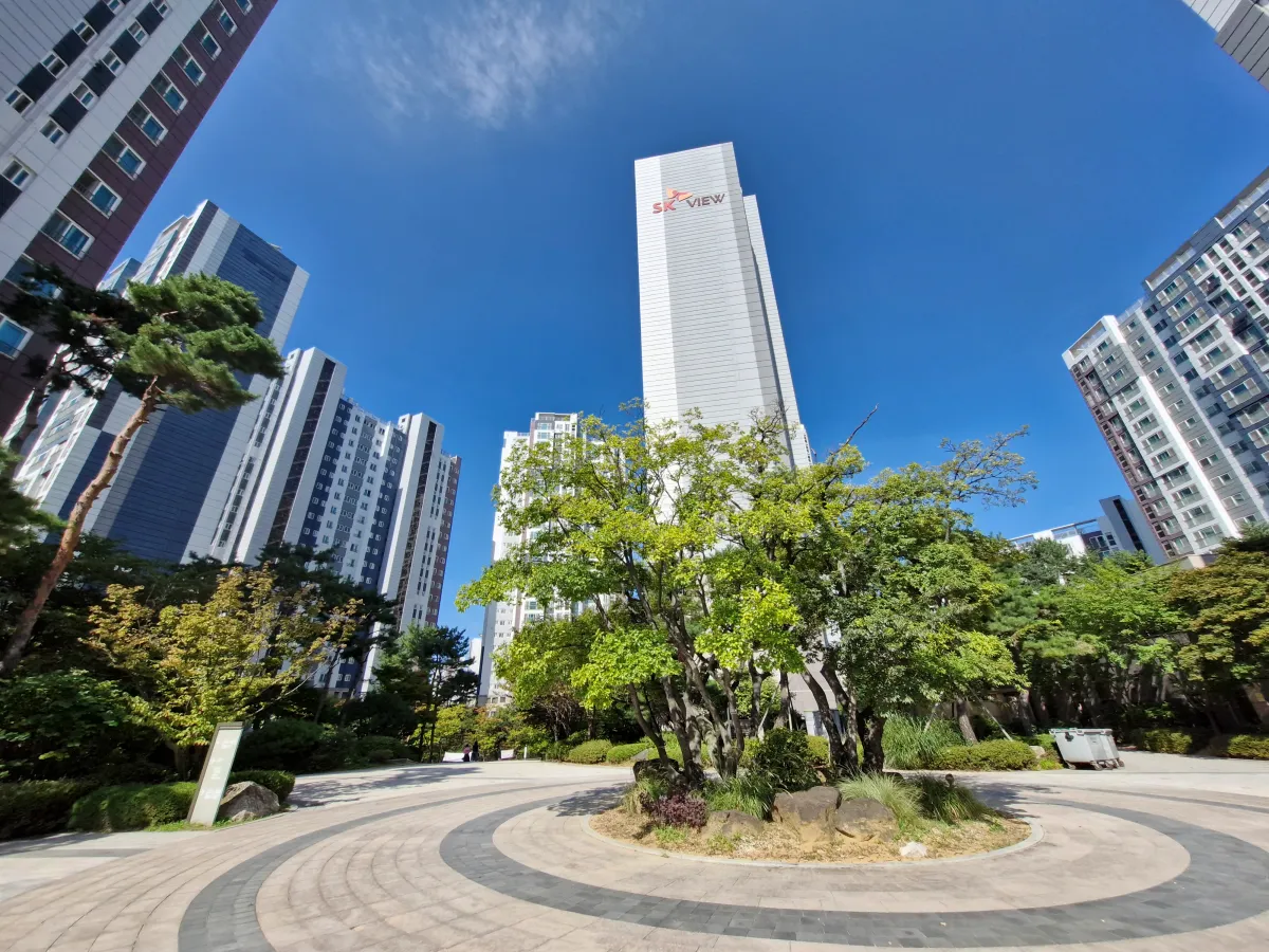 가운데-원반형으로-나무가-돋보이는-신축아파트