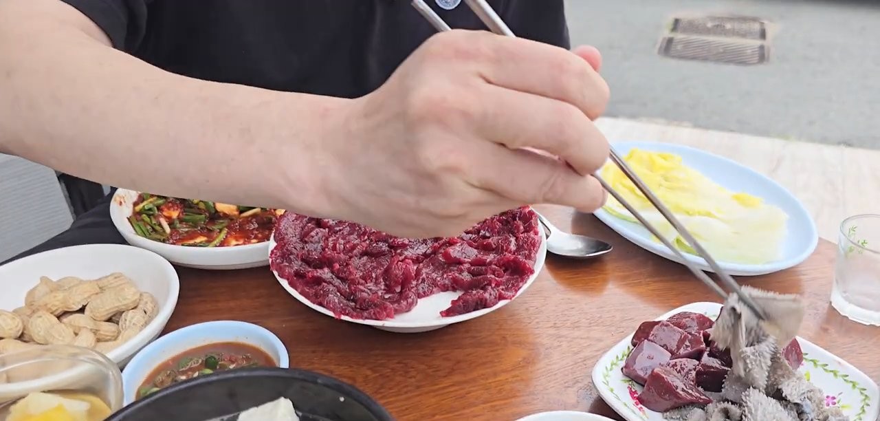 육회를 참기름장에 찍는 모습
