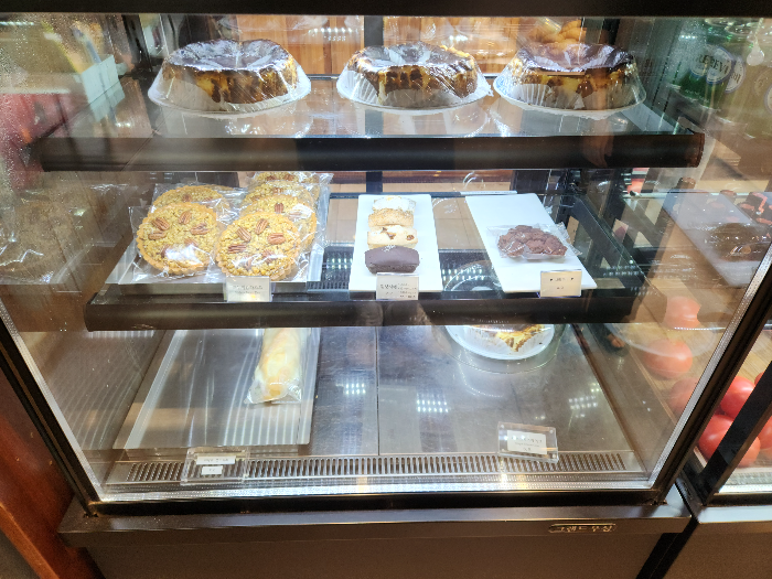 피칸 타르트&amp;#44; 휘낭시에&amp;#44; 브라우니&amp;#44; 치즈케이크가 진열장에 진열되어 있다