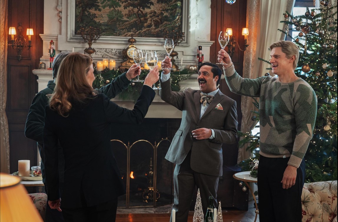 샴페인 프라블럼에서 크리스마스 분위기 속 인물들이 샴페인 잔을 들고 건배하는 장면 – 따뜻한 연말 감성이 돋보이는 스틸컷