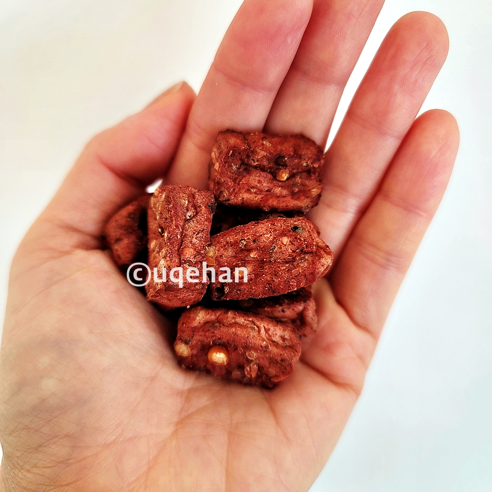 바우와우 오븐에 구운 단백질바 미니가 손바닥 위에 덜어져 있다.