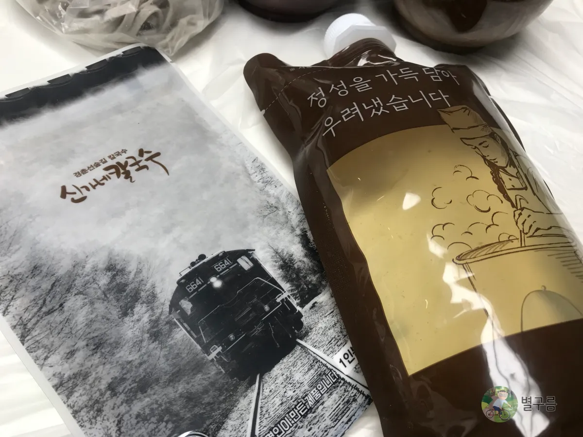 신가네칼국수-들깨칼국수-패키지-육수와-들깨가루가-나란히-있다