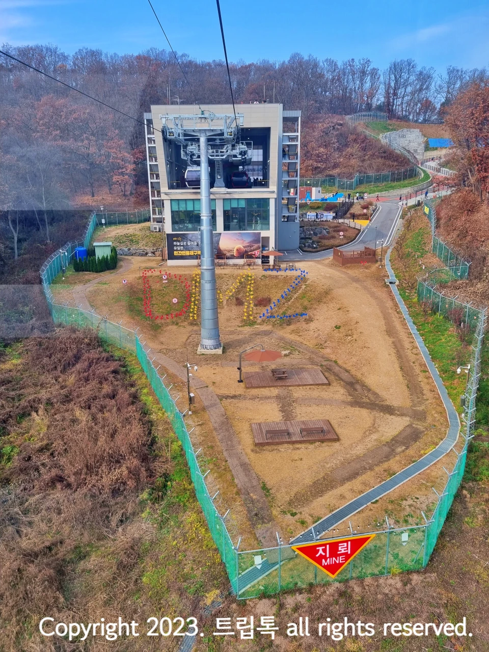 하얀 네모 모양의 전망대 아래 빨강, 노랑,파랑 색으로 DMZ라고 써있고 그 아래 빨간색으로 지뢰라고 표시되어있다.