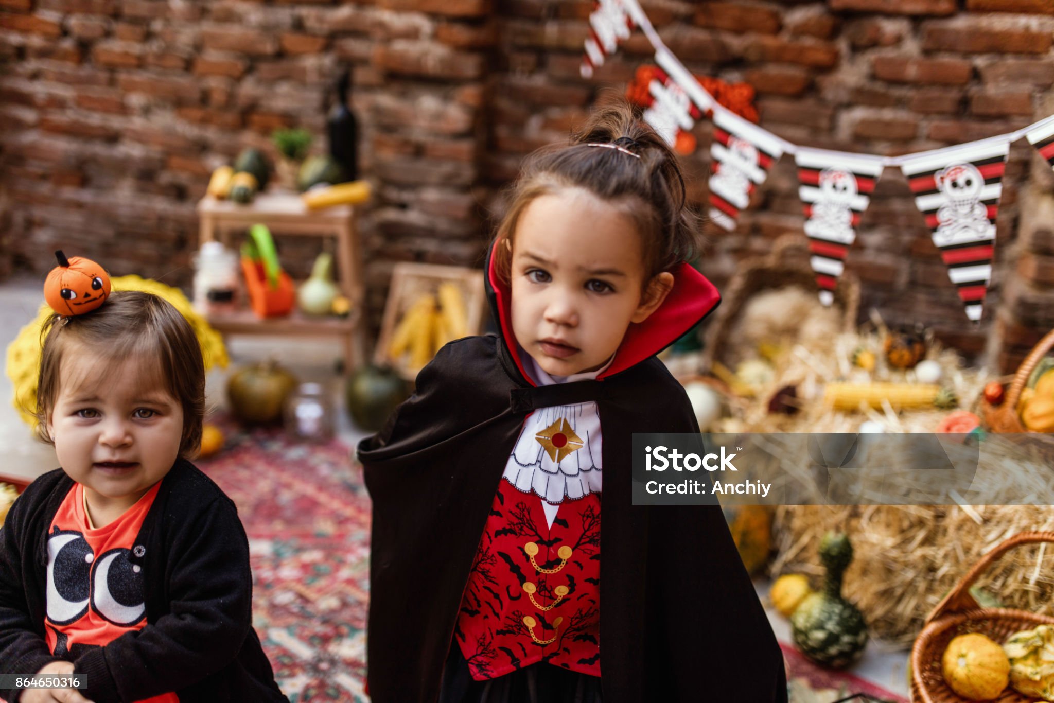 귀여운 여자 어린이가 드라큘라 백작의 가운을 입고 찍은 사진입니다.