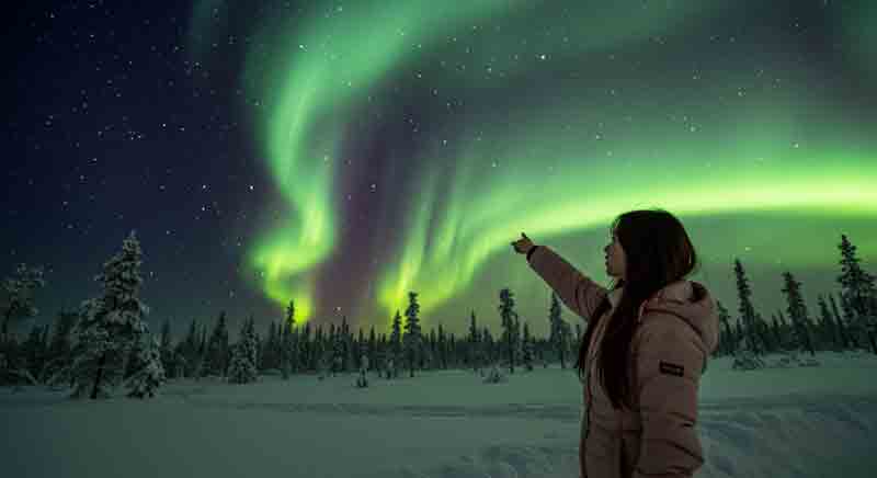 신비로운 오로라를 바라보고 있는 여성