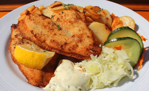 동그란 하얀 접시에 가자미 튀김 2마리와 오리 슬라이스, 양배추채가 있다.