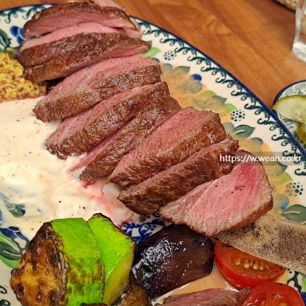 스테이크와 구운야채가 접시에 있습니다.