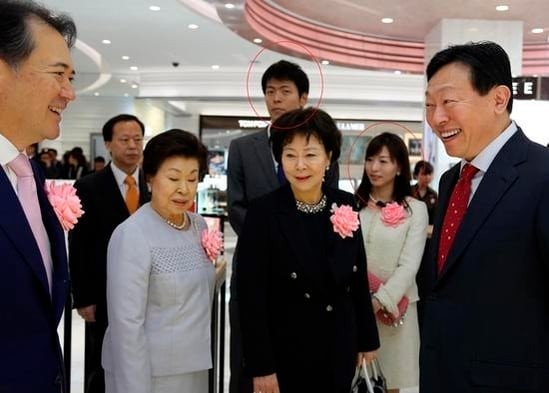 신동빈(오른쪽) 롯데그룹 회장이 2016년 3월 31일 일본 도쿄에서 열린 롯데면세점 긴자 매장 개점식에서 참가자와 대화하고 있다. 신 회장의 누나인 신영자(가운데) 전 롯데복지재단 의장과 어머니(앞줄 왼쪽 두번째), 신 회장의 아들 유열 씨 부부(붉은 원) 등이 함께 자리했다.