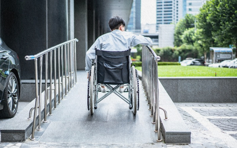 휠체어를 타고 오르막길을 오르는 어린아이