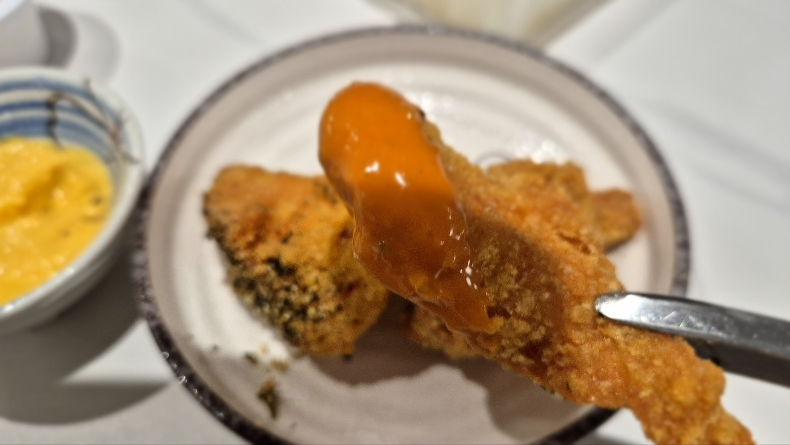 붉은 소스를 찍은 치킨