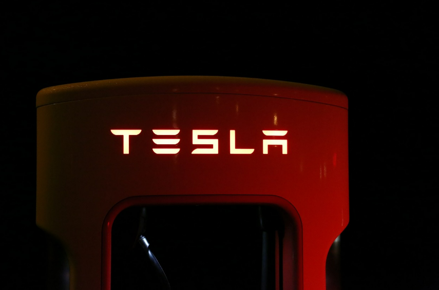 어두운 저녁 자동차회사 테슬라의 EV CHARGER에서 빛을내고 있는 테슬라 로고