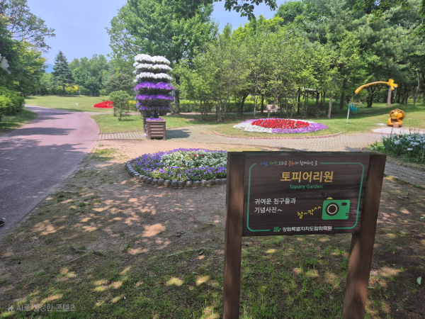 토피어리원 안내판과 꽃으로 장식된 다양한 모양의 토피어리 조형물