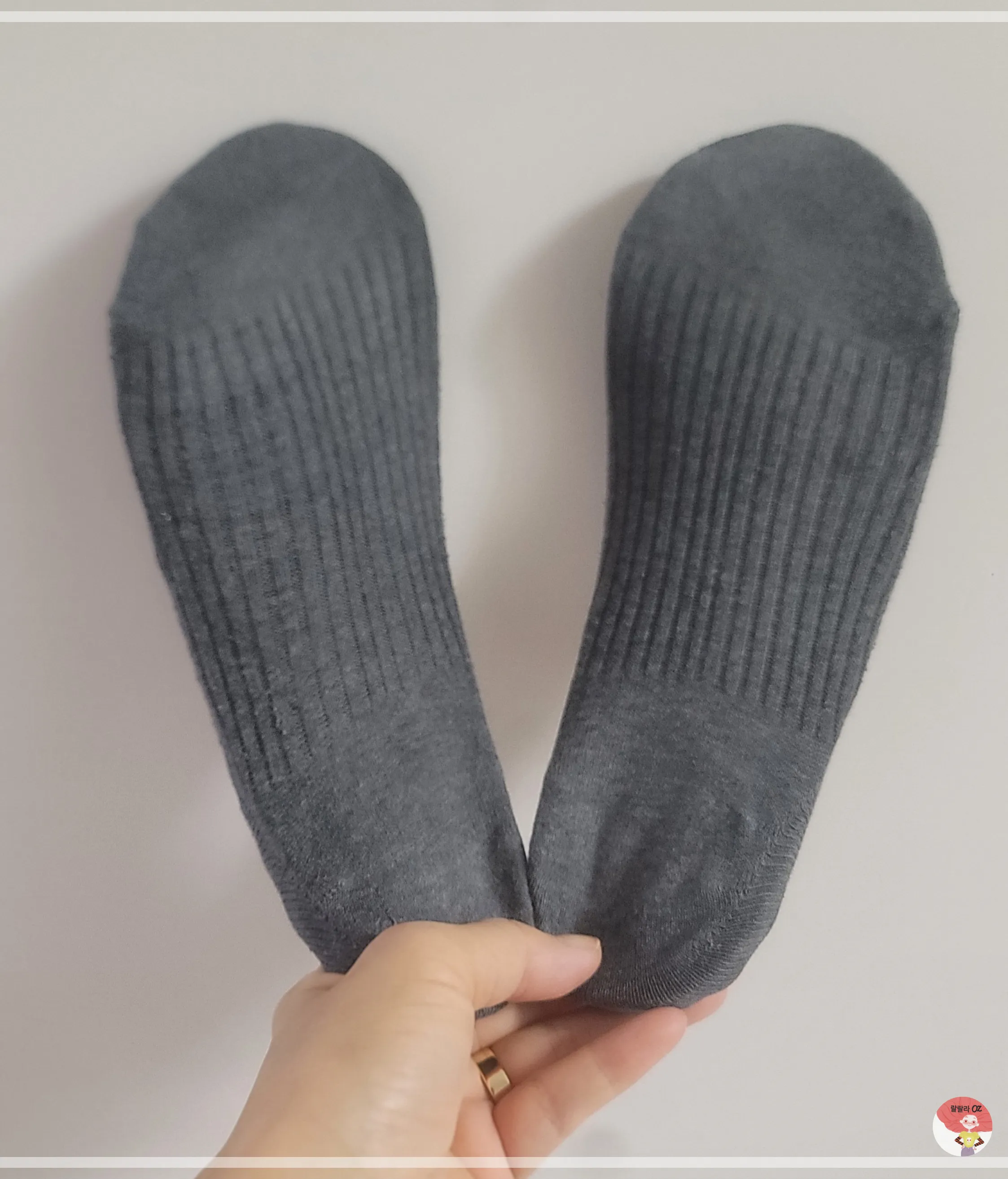 손에 들린 깔창에 짙은 회색 골지 양말을 씌움