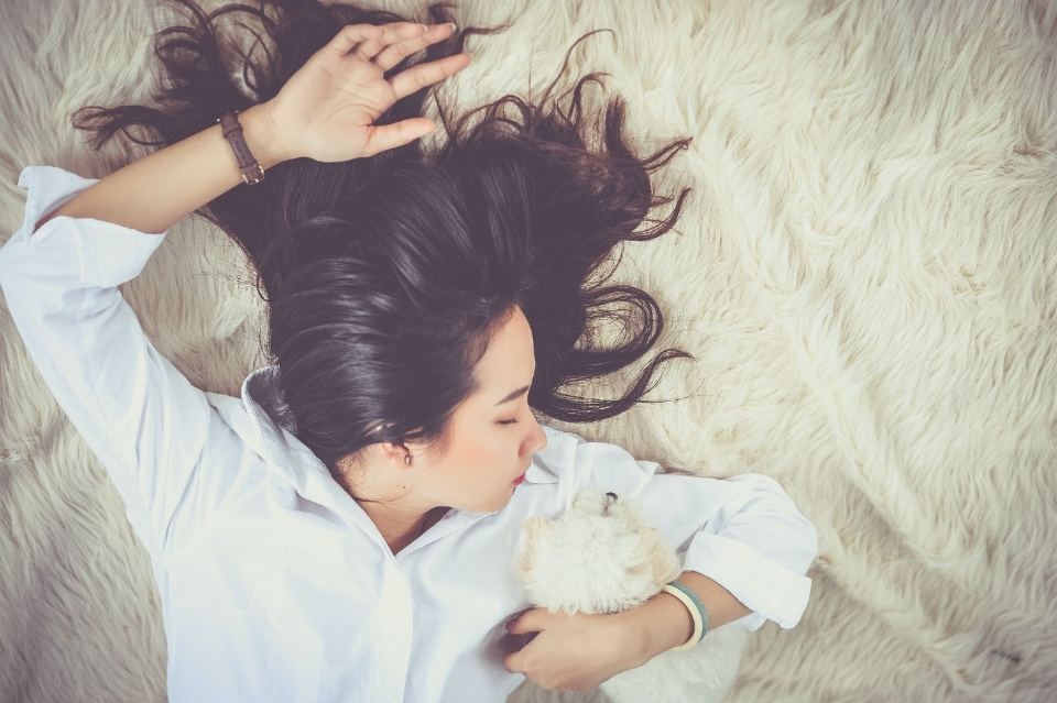 강아지를 안고 잠자고 있는 여자 사진