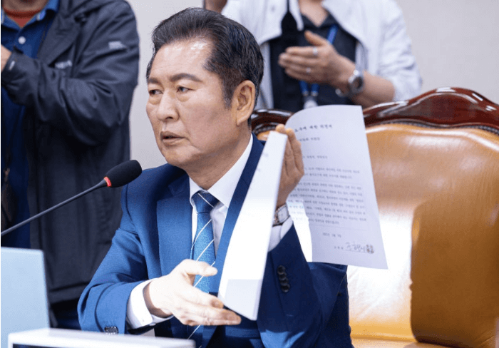 정청래 대표가 문서를 펼쳐놓고 설명하고 있다.