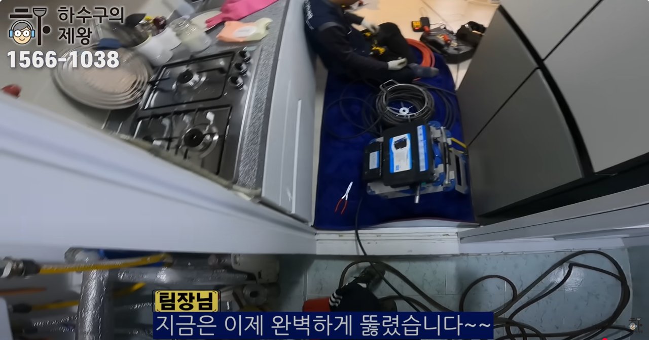 씽크대 배관 막힘 문제를 해결한 후 장비를 정리하고 있는 배관 전문 업체의 작업 현장 전경