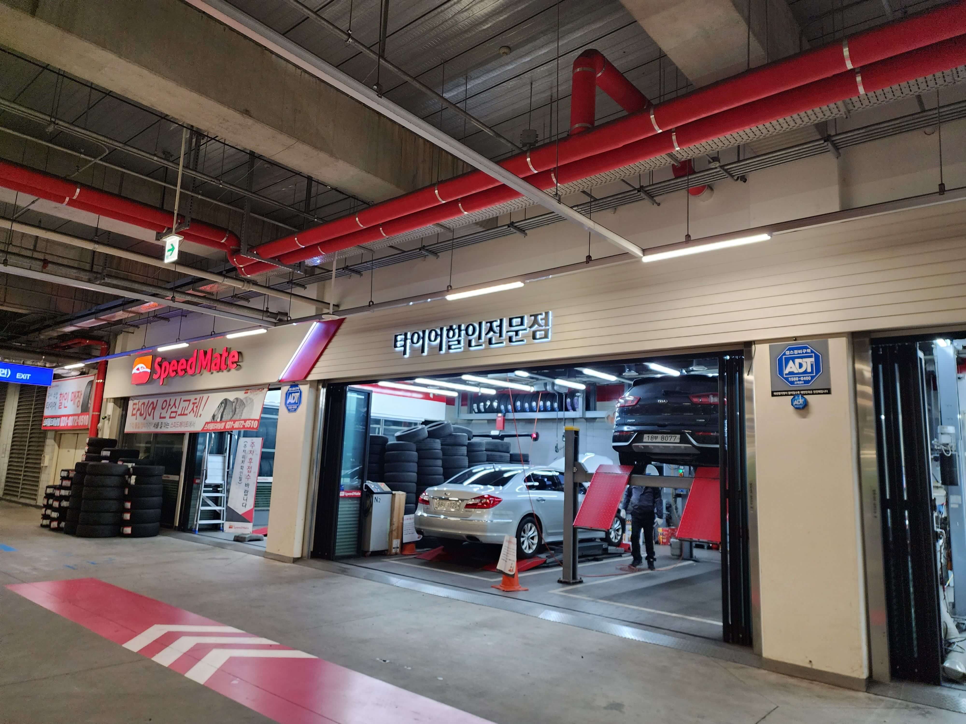 자동차 수리기사와 타이어 교체하는 자동차