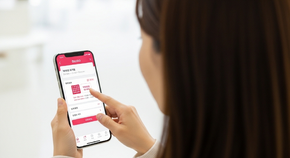 스마트폰 앱 화면으로 다이소 운영시간 확인하는 여성
