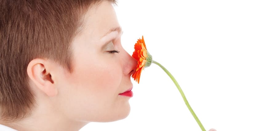 코에 꽃을 대고 있는 여자