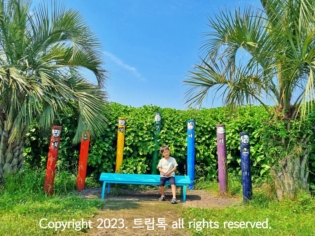 무지개색으로 기둥이 있고 그 가운데 의자가 있다