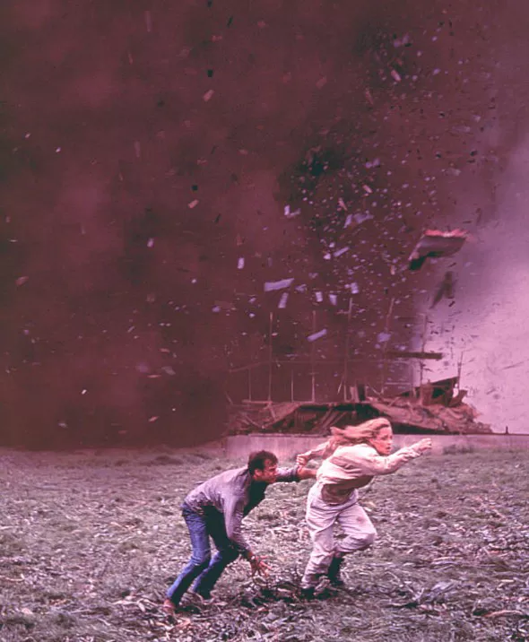 토네이도가 파괴한 집의 파편을 피해 달아나는 두 사람