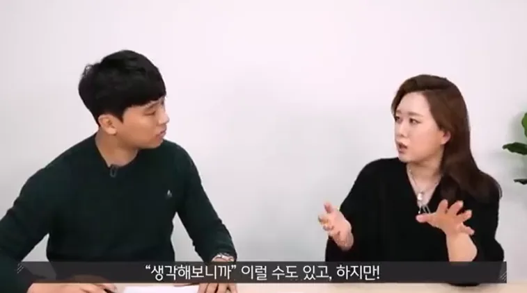 남녀 출연자가 대화를 나누는 인터뷰 영상에서 여성이 자신의 생각을 설명하며 손짓하는 장면
