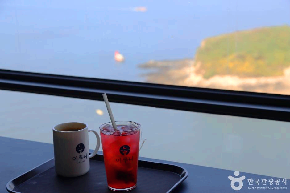 호수가 보이는 창가 에 음료 두잔이 있다.