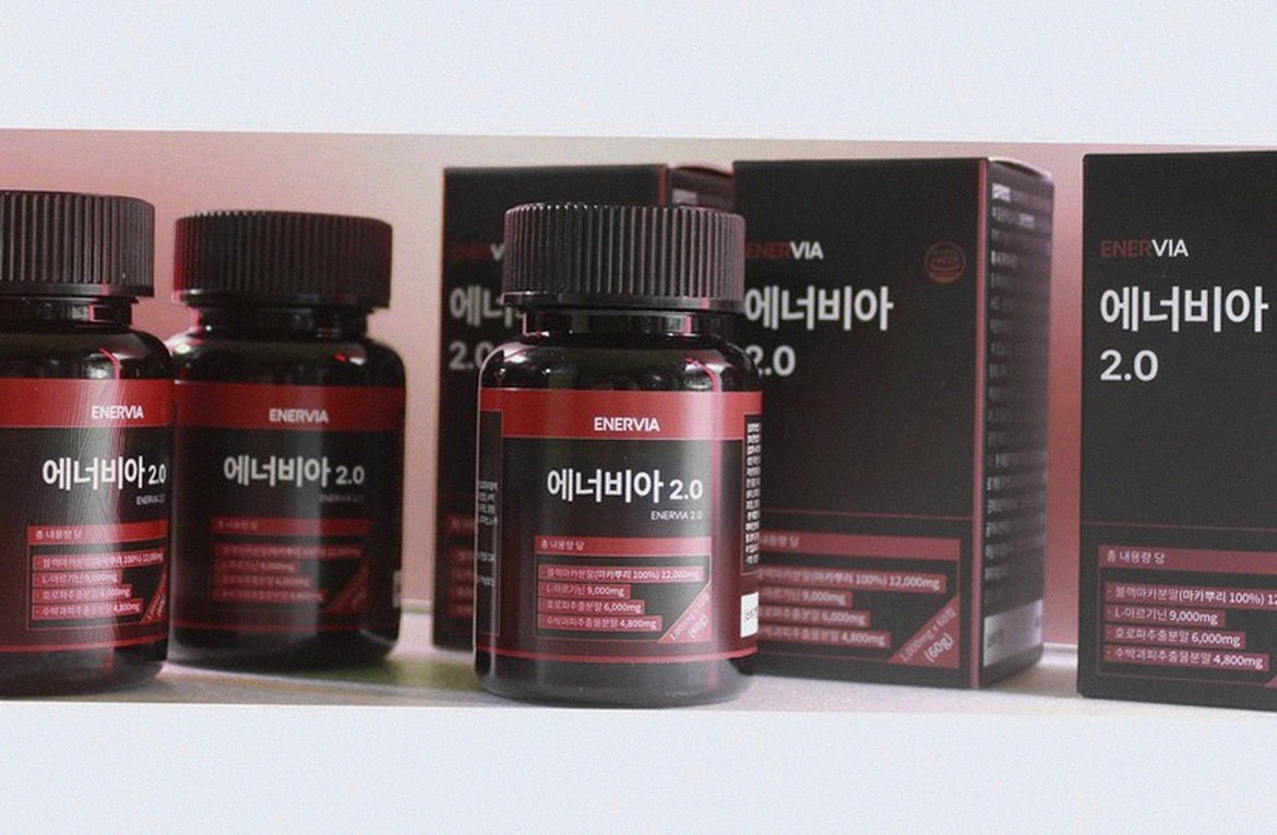 Korean Asian man at office desk with supplement bottle and water