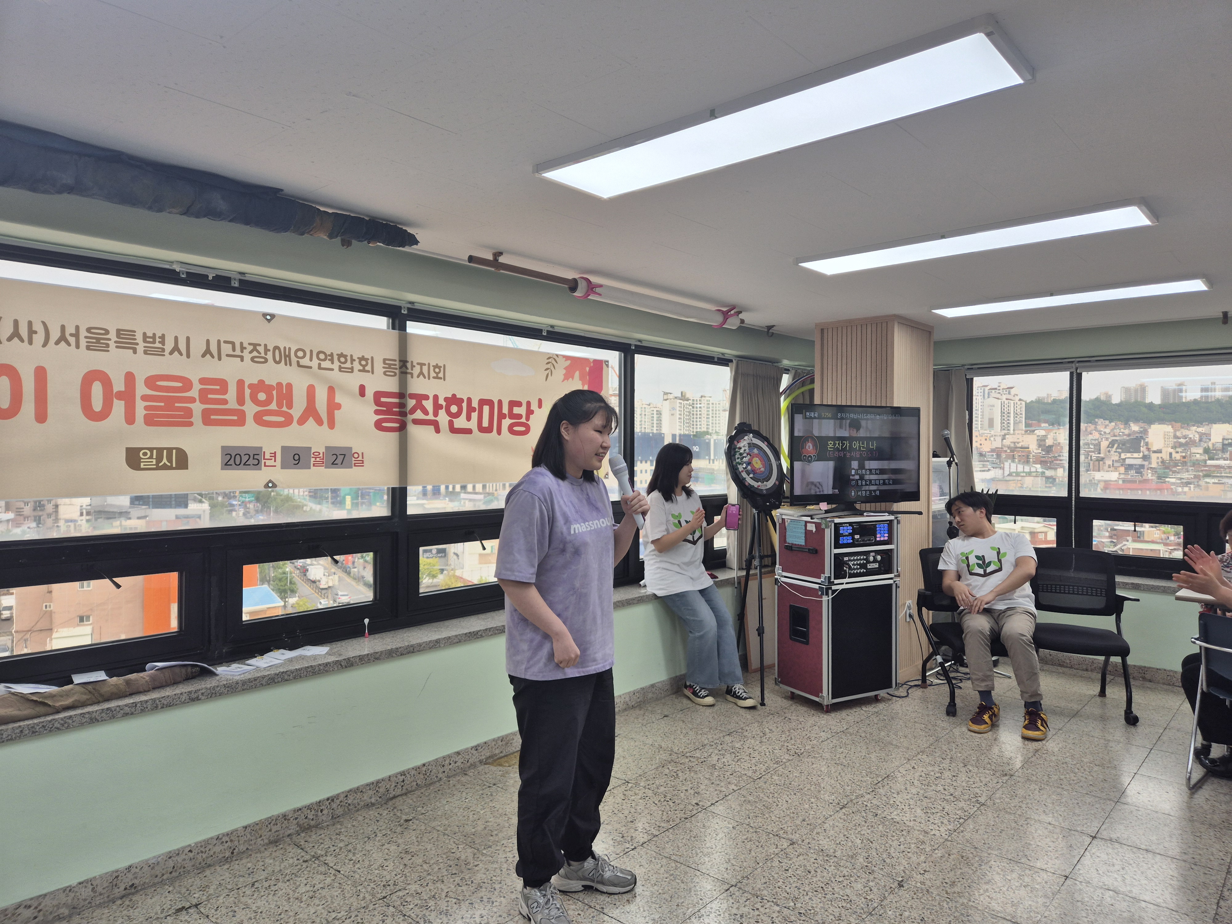 지회원이 무대앞에 나와 노래를 부르고 있다.