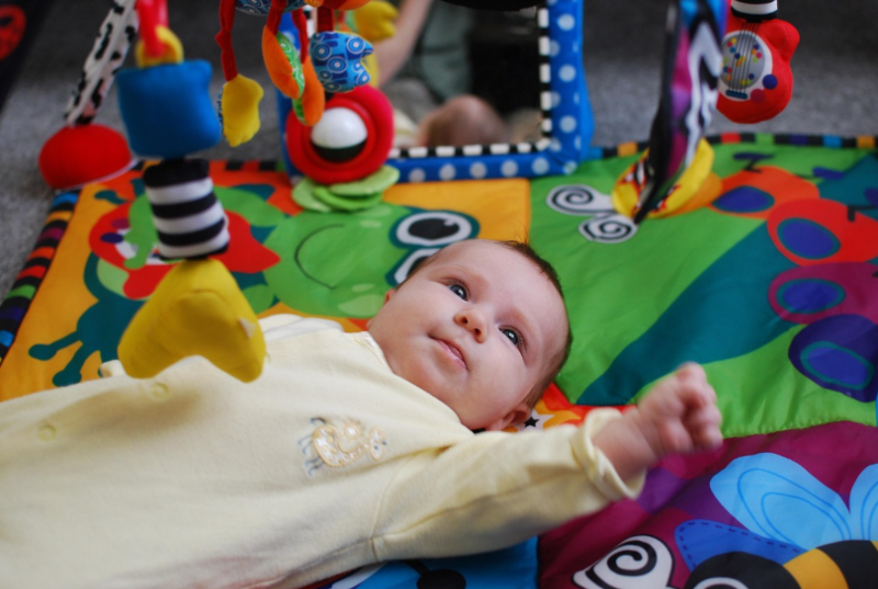 신생아 놀이매트 위 터미타임 모습, 아기 감각 발달 장난감과 모빌을 바라보는 영아 발달 자극 놀이 이미지, 집에서 하는 아기 놀이 활동